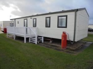 a white trailer with a red fire hydrant next to it at 8 Berth Central heated Golden Palm (Aspen GP) in Chapel Saint Leonards