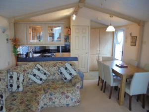 a living room and kitchen with a couch and a table at 8 Berth Central heated Golden Palm (Aspen GP) in Chapel Saint Leonards