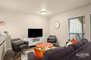 a living room with a couch and chairs and a tv at Minutes to Zilker, Barton Springs and Free Parking in Austin