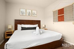 a bedroom with a large white bed with towels on it at Minutes to Zilker, Barton Springs and Free Parking in Austin