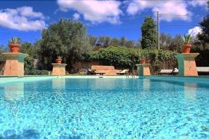 uma grande piscina com água azul em La Baronia em Trapani