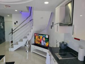 sala de estar con TV y escalera en Kandi Tower 3, premium 1BR with 2CR & 2 balcony. en Ángeles