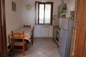 een kleine keuken met een tafel en een koelkast bij Casa vacanza Riparbella in Riparbella
