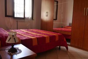een slaapkamer met een bed, een tafel en een spiegel bij Casa vacanza Riparbella in Riparbella