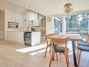 een keuken en eetkamer met een tafel en stoelen bij Holiday home Nexø XLII in Neksø