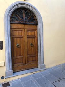 een houten deur in een gebouw met een boog bij Appartamento con vista panoramica in Campagnatico