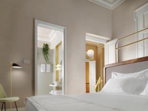1 dormitorio con cama blanca y espejo en Monument, en Atenas