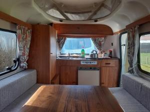 een keuken met een houten tafel in een camper bij Sundial Cottage Eriba Caravan in Norwich