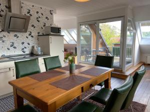 a kitchen and dining room with a wooden table and chairs at Kleemann´s Apartment**** in Zossen