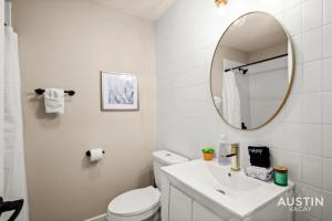 a white bathroom with a sink and a mirror at Walk to Restaurants or Cook in Subway Tile Kitchen in Austin +15 photos