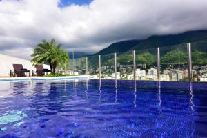 a swimming pool with a city in the background at Pestana Caracas Premium City & Conference Hotel in Caracas