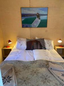 1 dormitorio con 1 cama con una pintura en la pared en Audkula Dome Cabin, en Hella