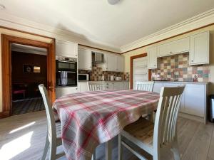 a kitchen with a table and chairs in a room at Balloan House in Dornoch