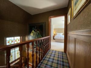 a hallway with a staircase leading to a bedroom at Balloan House in Dornoch