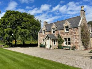 an old stone house with a large yard at Balloan House in Dornoch