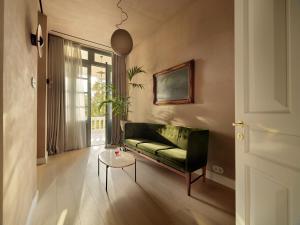 a living room with a green couch and a table at Monument in Athens