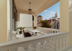 雅典的住宿－Monument，阳台配有桌椅,享有教堂的景致。