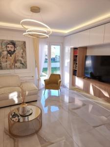 een woonkamer met een bank en een tv bij Villa with Pool & Garden apartment 2 Vuk in Tivat