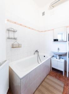 Baño blanco con bañera y lavamanos en Silvie Apartments - Šmeralova, en Olomouc