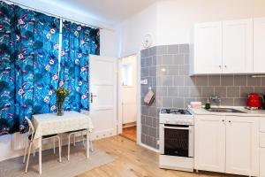 cocina con mesa y cortina de ducha azul en Silvie Apartments - Šmeralova, en Olomouc