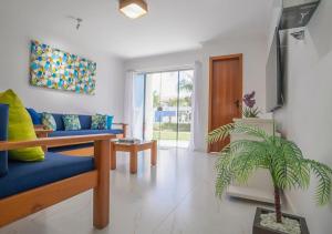 a living room with a blue couch and a plant at DUPLEX 2 SUÍTES MONT SIÃO in Porto Seguro
