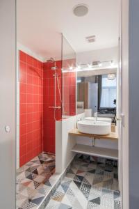 uma casa de banho com lavatório e azulejos vermelhos em MIZU House by Prague Days em Praga