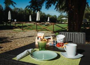 una mesa con un plato de comida y dos tazas en Agriturismo La Siesta, en Marsiliana