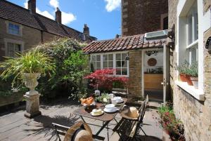 a patio with a table and chairs in front of a house at Charming Cottage in the Heart of Frome - Sun House in Frome