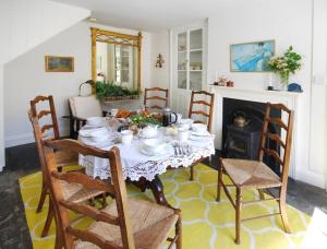 a dining room with a table and chairs and a fireplace at Charming Cottage in the Heart of Frome - Sun House in Frome