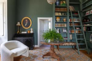ein Wohnzimmer mit grünen Wänden, einem Tisch und einem Stuhl in der Unterkunft Stunning refurbished Chateau in South West France in Ornézan