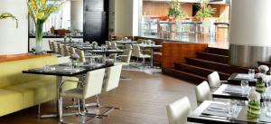 a dining room with tables and white chairs at Pestana Caracas Premium City & Conference Hotel in Caracas