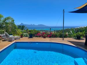 a swimming pool with a view of the ocean at Villa Green in Punaauia