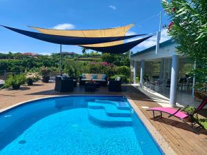 a swimming pool with a canopy over a house at Villa Green in Punaauia +40 photos