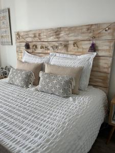 a bedroom with a bed with a wooden headboard and pillows at Studios Nuitée en Provence in Aix-en-Provence