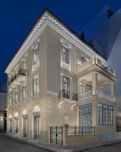 un gran edificio blanco con balcón en Monument, en Atenas