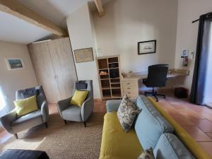 a living room with a couch and two chairs and a desk at La Chouette de Camargue in Aigues-Mortes