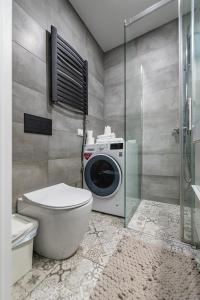 a bathroom with a washing machine and a toilet at Shanti barracks apartment by Polo Apartments in Kaunas +22 photos