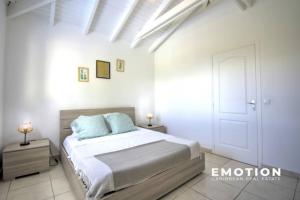 1 dormitorio blanco con 1 cama y techo blanco en Superbe logement à quelques pas de la plage, en Saint Martin