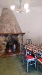 comedor con mesa y chimenea de piedra en Casa del Parque en Tandil
