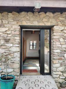 una porta per un edificio in pietra con una pianta in vaso di Kingsford renovated old cottage a Wexford