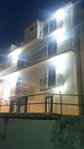 un edificio blanco con balcones por la noche en B&B Il Belvedere Viggiano, en Viggiano