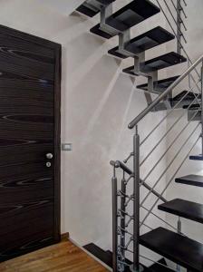 eine Wendeltreppe in einem Haus mit einer schwarzen Tür in der Unterkunft B&B Il Belvedere Viggiano in Viggiano