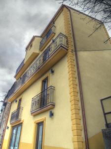 un edificio amarillo con balcones en un lateral en B&B Il Belvedere Viggiano, en Viggiano