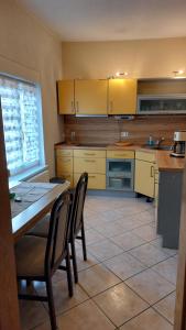 a kitchen with yellow cabinets and a table and chairs at Marie's Küsten Zauber in Bentwisch