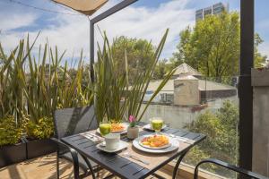 een tafel met twee borden eten op een balkon bij The Gallery in Mexico-Stad