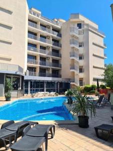a swimming pool in front of a large building at Joy Apartment Sunny Beach in Sunny Beach