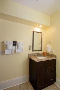 a bathroom with a sink and a mirror and towels at Hemingway House Bed and Breakfast in St. Augustine