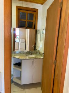 bagno con lavandino e specchio di Casa Aconchegante ou Suítes Privativas a Canela