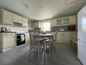 a kitchen with a table and chairs in it at Balloan Cottage in Dornoch