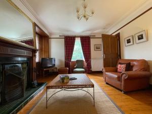 a living room with a couch and a fireplace at Balloan Cottage in Dornoch